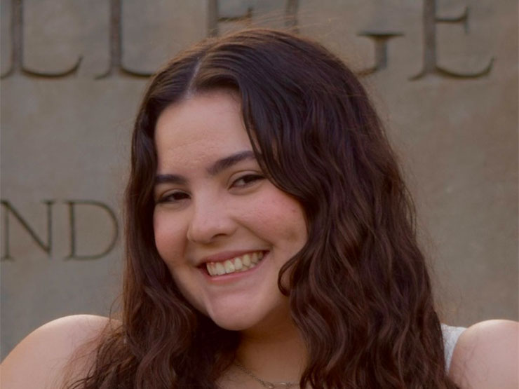 A smiling college student with brown hair.