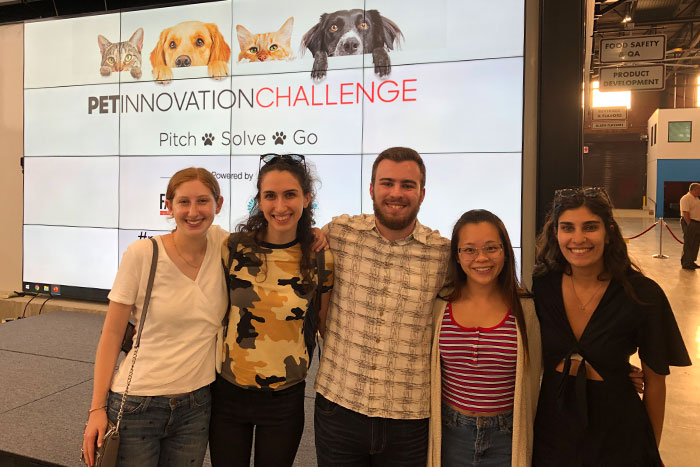 Group of students standing in front of a large monitor