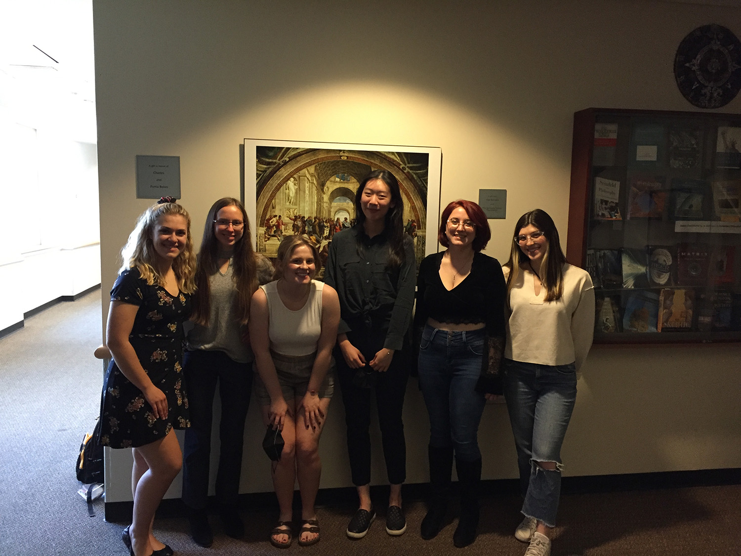 Students standing in a group against wall with spotlight shining.