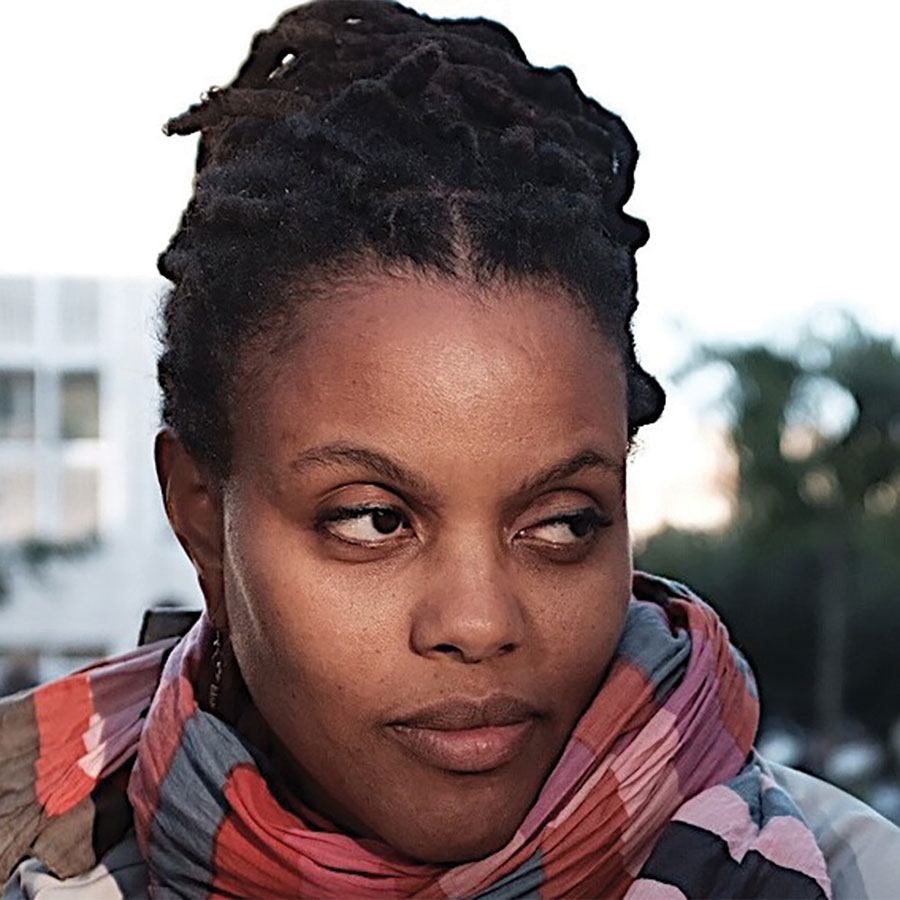 A headshot of a college professor wearing a colorful scarf.