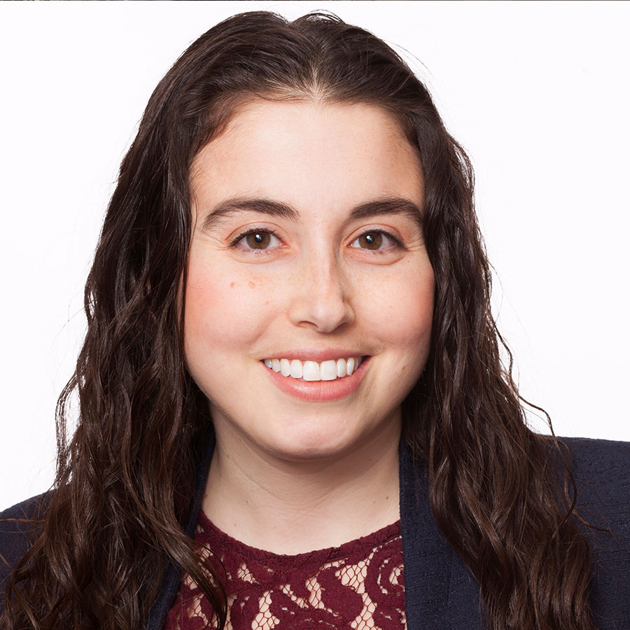 Muhlenberg College alumni standing in front of white backdrop smiling pose for portrait.