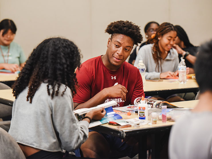 College students chat while working together in a collage workshop.