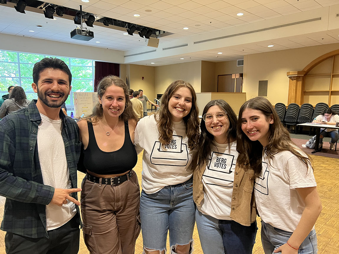 A group of college students smiles for the camera; a few of them are wearing white t-shirts that say BergVotes