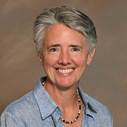 A headshot of a college professor wearing a blue collared shirt