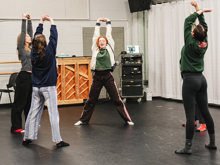 A group of Muhlenberg students stretch in a dance class.